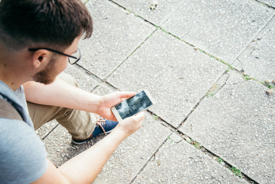 Man Holding Smartphone With Cracked Screen