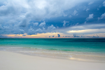 Landscape of beautiful sunset in Maldives island sandy beach with colorful sky over wavy sea