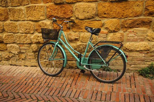 Old bicycle near red brick wall