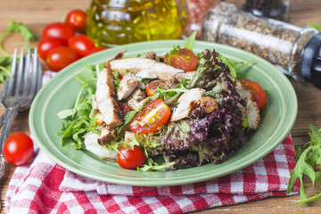 Fresh salad with chicken breast, arugula and tomato. Top view