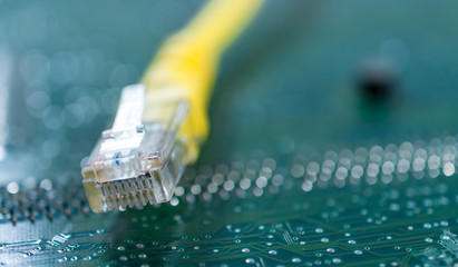 Yellow internet switch close up on computer circuit board.