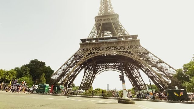 Street traffic time lapse near the Eiffel tower during rush hours in Paris, France. Summer cityscape, city life and famous touristic places and landmarks in Europe. Transportation and tourism concept