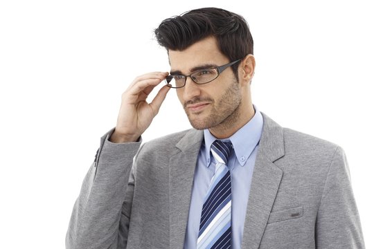Young businessman fixing glasses