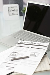 Close-up photo of laptop and papers