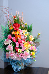 Multicolor of artificial Flowers on the table decorate the room with grey background
