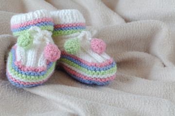 Fototapeta na wymiar Newborn acessories, small shoes on soft background