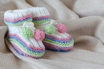 Fototapeta na wymiar Newborn acessories, small shoes on soft background