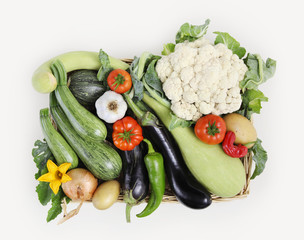 top view basket of vegetables, cauliflower, tomatoes, zucchini, potatoes, eggplants, peppers, onions and garlic, isolated on white background