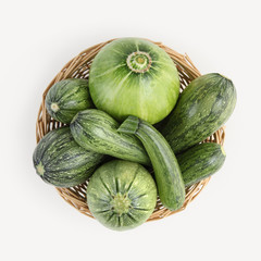 top view wicker basket of zucchini isolated on white background