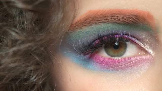Colorful eye makeup and hair. Beautiful glitter eyeshadow.