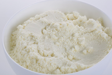 Closeup of powder milk in a white bowl.