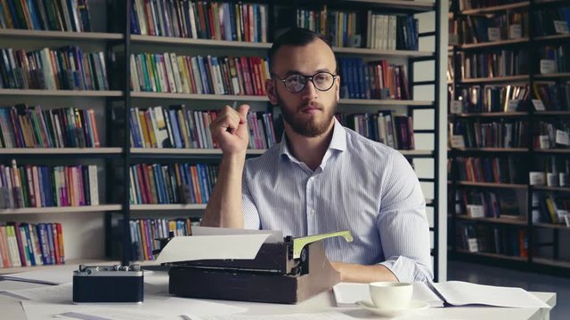 Young writer with glasses typing text