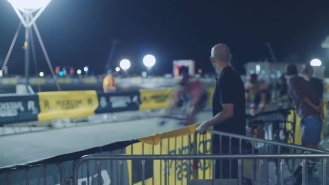 View on cycle race event at night time, many riders on track bikes with fixed gear riding away in their final race