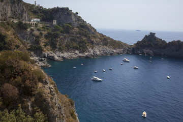 Fototapeta na wymiar Piccolo golfo naturale lugno la costiera amalfitana tra Positano e Amalfi. Il mare è calmo e le barche dei turisti sono ancorate. L'acqua è pulita e blu e il cielo è splendente.
