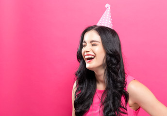 Young woman with party theme on a pink background