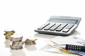 Finanzen, Euro, Bargeld, Taschenrechner und Kugelschreiber vor weißem Hintergrund