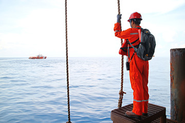 The worker prepare swing rope from platform to supply boat or passenger ship at oil and gas remote platform  for working at the wellhead platform or remote platform. 