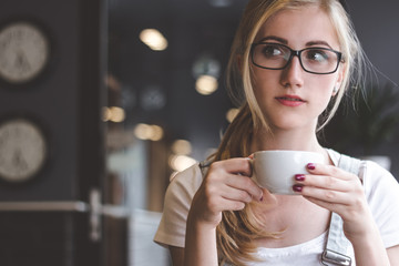 Enjoying a warm cup of comfort. Portrait of an attractive young woman enjoying a cappuccino in a coffee shop