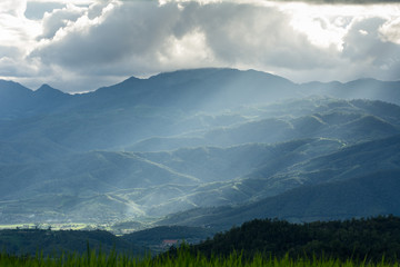 Beautiful sun rays through the clouds over mountains,evening light,Amazing scene