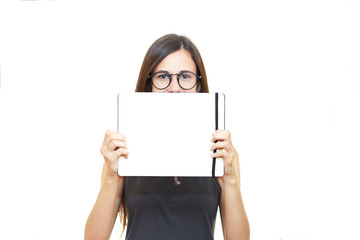Naklejka premium Young beautiful woman in glasses on white isolated background holds notebook teacher emotions