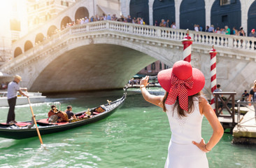Elegante, weibliche Touristin fotografiert die Rialto Brücke in Venedig, Italien