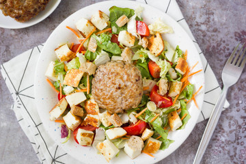 Fresh hamburger salad with grilled cheese top view, grey background.
