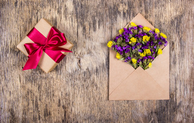Romantic message. A living letter. Wild flowers in the envelope and a box with a gift. Copy space