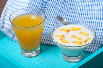 Yogurt with diced peaches and juice on the table.