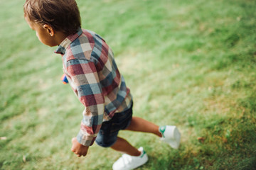 Baby boy walking in park on green grass