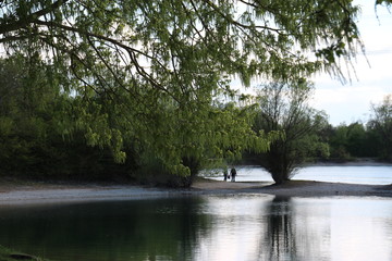 a day in autumn at the lake, still and calm, people going for a walk