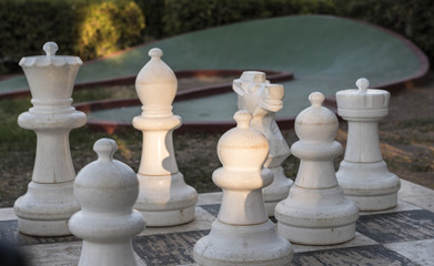giant chess figures on chessboard in the park