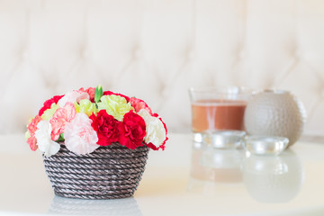 Colorful carnations in brown vase.