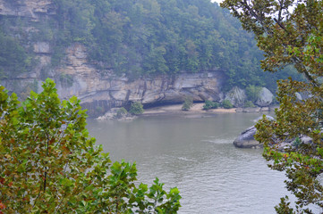 photo of the river bordered by rocky bluffs on a rainy day