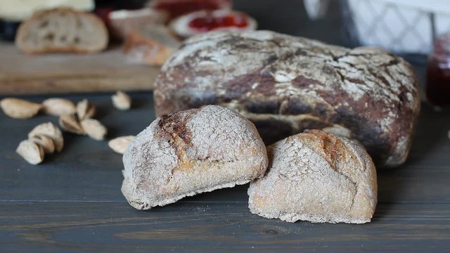 Close-up macro shot of black bread. Rolls lie on a wooden table of dark wood. The flour is scattered on the table.