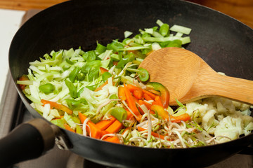 Sauteed vegetables with chicken, pork, jam and shrimps preparation : Cooking vegetables into a wok