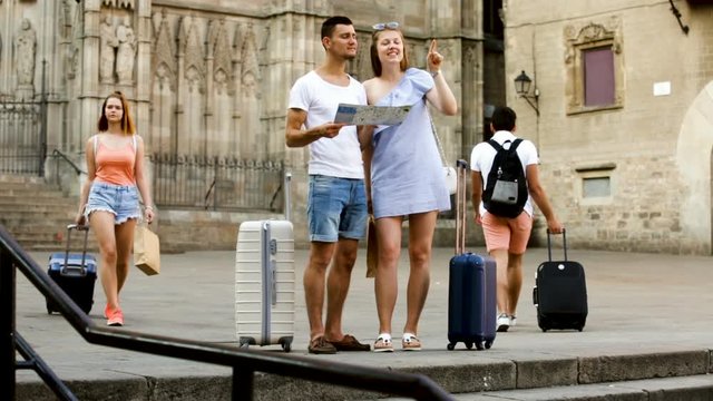 Portrait of tourists with map and baggage in European city
