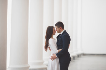 Beautiful couple, bride and groom posing near big white column