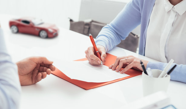 Driver signing a car insurance