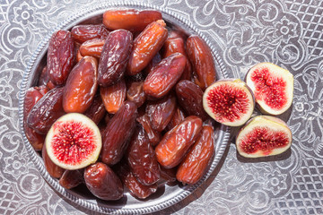 Dried dates in a silver bowl.