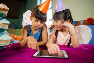 Little girls using tablet at party