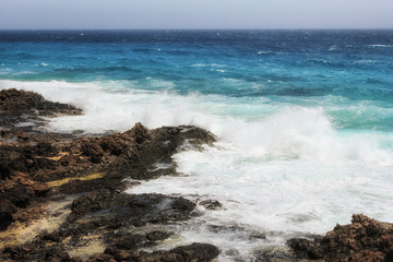 Fototapeta na wymiar Waves of the Ocean crashing against the rocks