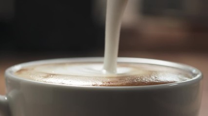 Slow motion closeup pour steamed milk into cappuccino - Powered by Adobe