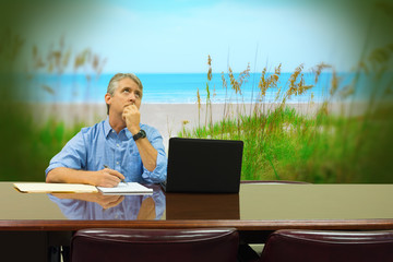 Stressed out man at work who is suppose to be working hard is daydreaming about a beautiful, peaceful, beach vacation with no people around so he would be happy and enjoying life.
