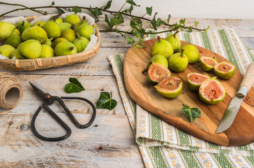 Whole figs and figs sliced in half on top of a rustic wooden table.