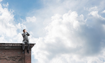 Young man on building edge do not want to see anything