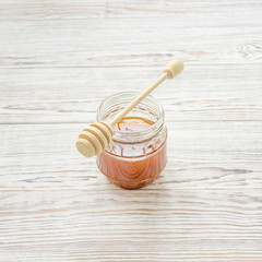 Jar of honey with honey stick