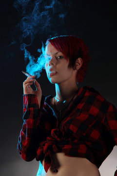 Eine Frau raucht eine Zigarette in der Dunkelheit