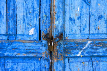 Eine blaue altertümliche Holztür mit Vorhängeschloss 