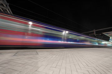 Long distance express train departing station and gathering speed