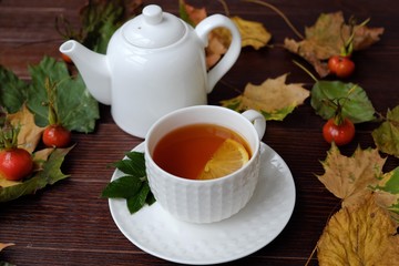 Tea with lemon on the table with autumn leaves 